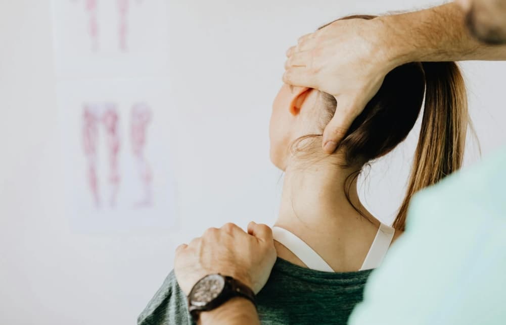 Kiropraktor som undersøker nakken til en pasient